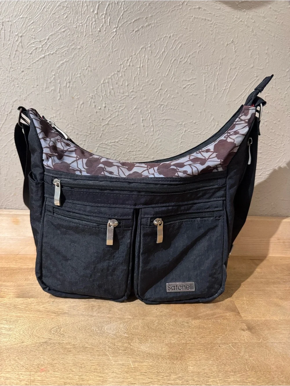 Satchelli Black Crossbody Bag with Floral Accent and Red Lining